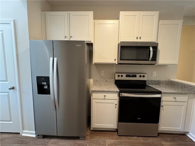 kitchen featuring dark hardwood / wood-style floors, stainless steel appliances, and white cabinets