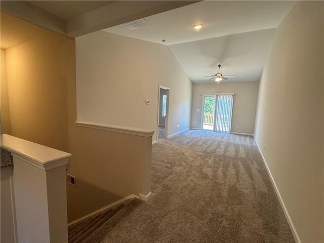 hallway with lofted ceiling and carpet flooring