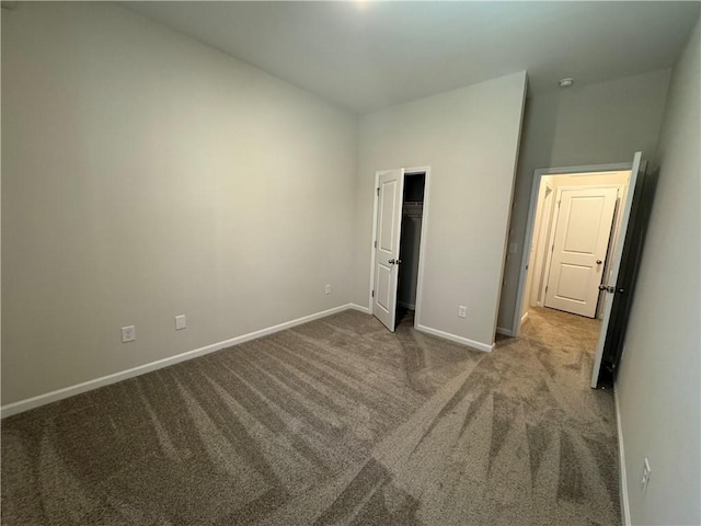 unfurnished bedroom with carpet flooring and a spacious closet