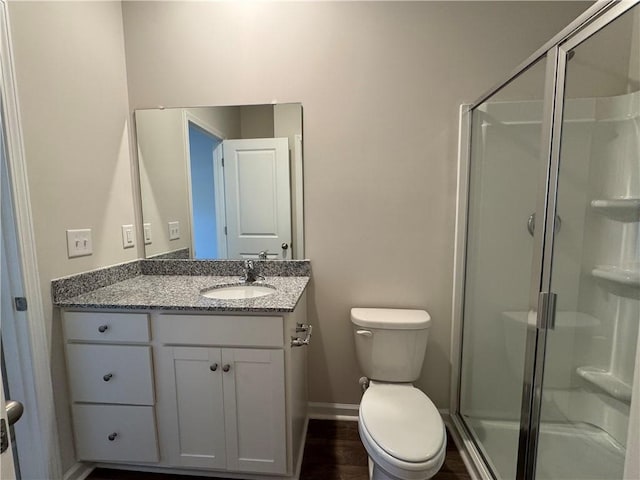 bathroom featuring walk in shower, vanity, toilet, and wood-type flooring