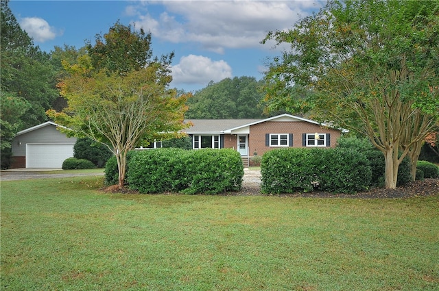 single story home featuring a front yard, a garage, and an outdoor structure