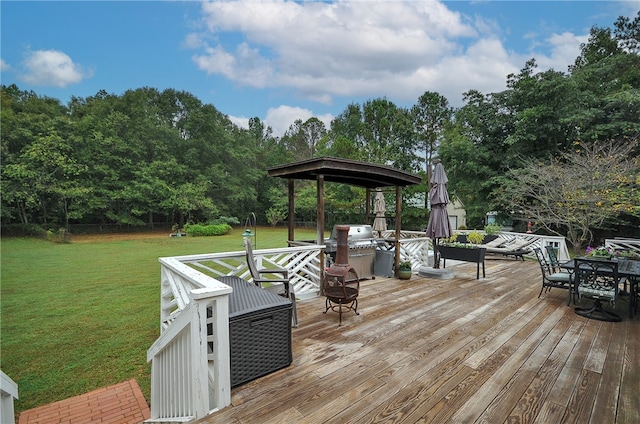 wooden deck featuring a yard and a fire pit