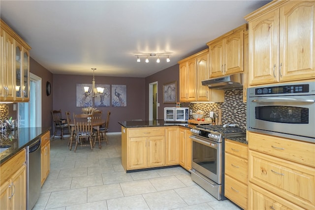 kitchen with dark stone counters, an inviting chandelier, decorative light fixtures, light tile patterned flooring, and stainless steel appliances