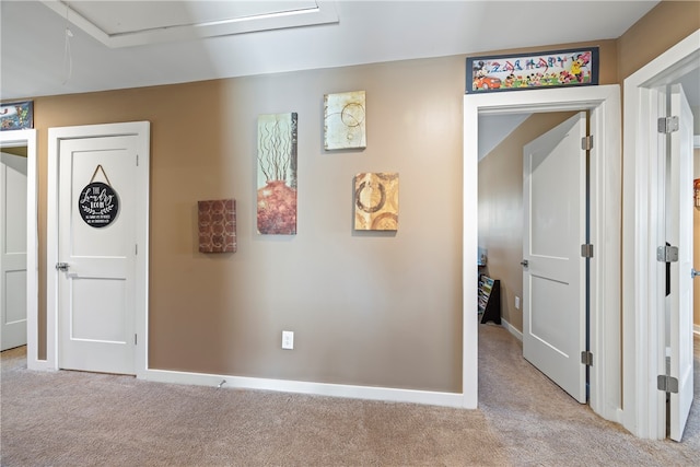 hall featuring light colored carpet