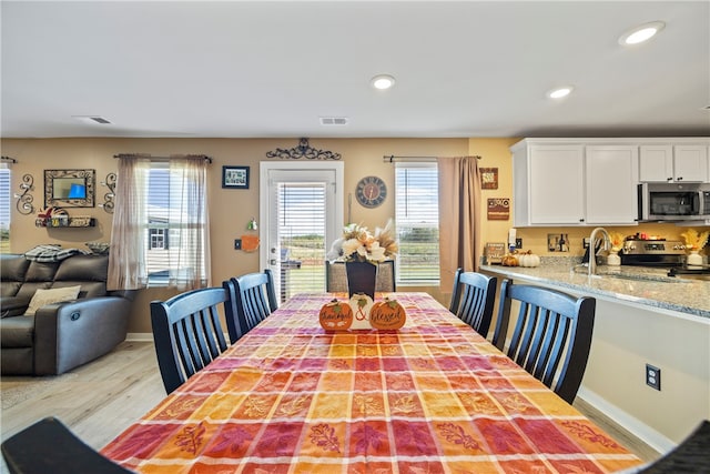 dining area with sink and light wood-type flooring