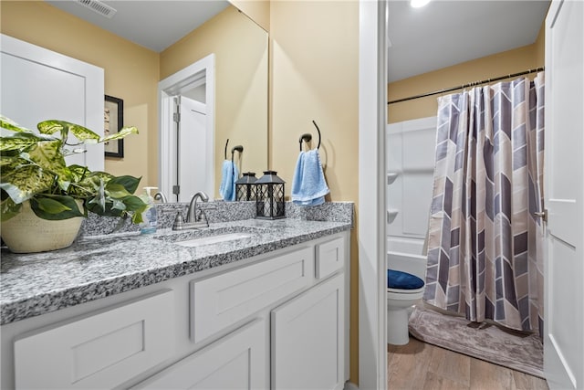 full bathroom with vanity, hardwood / wood-style floors, toilet, and shower / tub combo