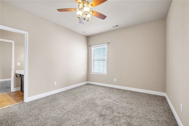 unfurnished room featuring a ceiling fan, carpet flooring, visible vents, and baseboards