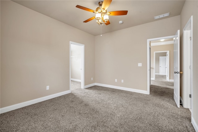 carpeted empty room with a ceiling fan, visible vents, and baseboards