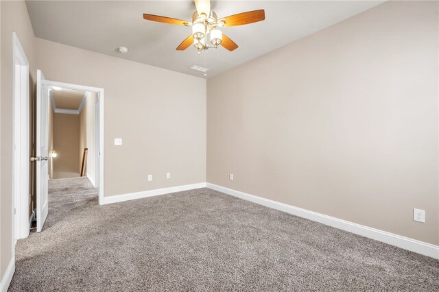 spare room with carpet floors, ceiling fan, and baseboards