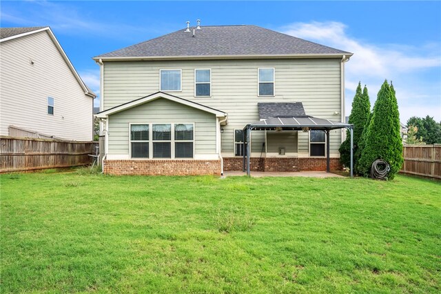 rear view of house with a fenced backyard, brick siding, a shingled roof, a yard, and a patio area