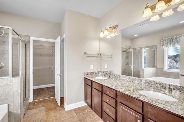 bathroom featuring a bath, a shower stall, a spacious closet, and a sink