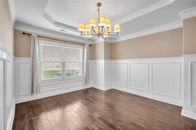 spare room featuring a chandelier, a decorative wall, dark wood-style flooring, visible vents, and crown molding