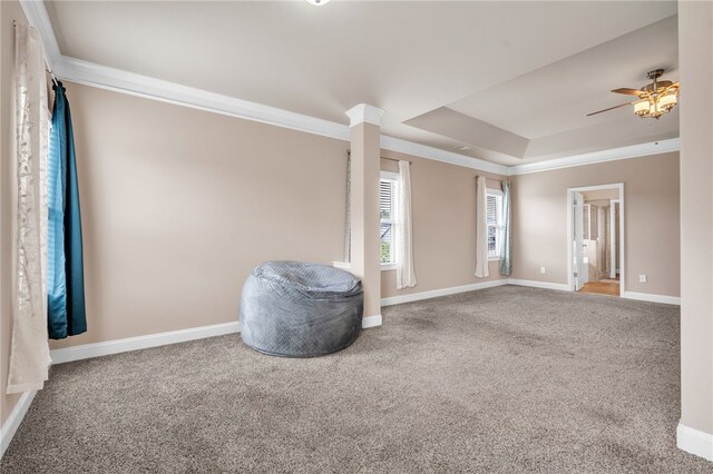 empty room featuring carpet floors, ornamental molding, baseboards, and ceiling fan