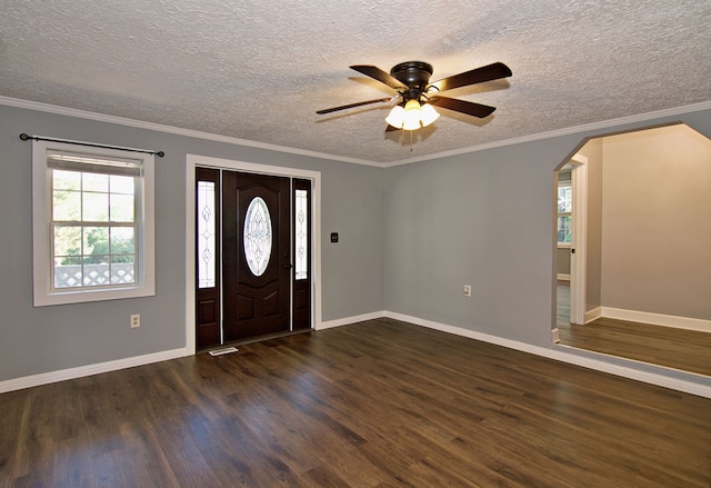 entryway with crown molding, ceiling fan, dark wood-type flooring, and a textured ceiling