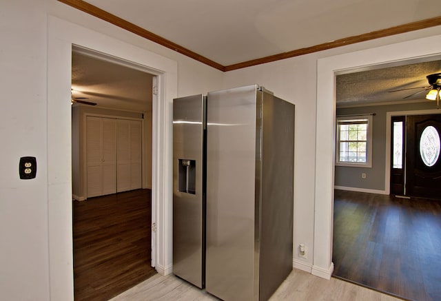 kitchen featuring ceiling fan, stainless steel fridge, light hardwood / wood-style flooring, ornamental molding, and a textured ceiling