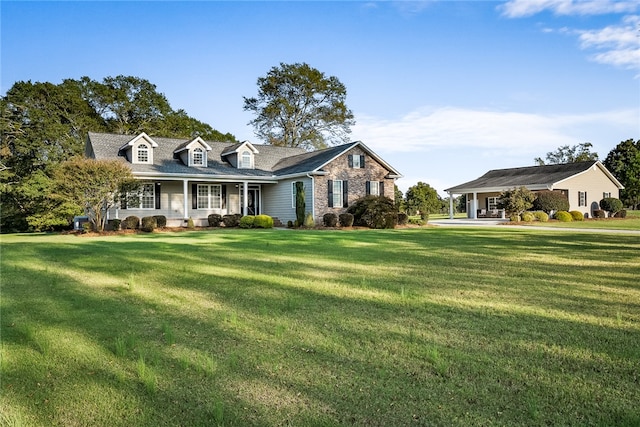 cape cod house with a front yard and covered porch