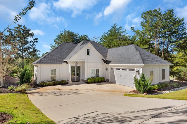 modern farmhouse style home with an attached garage, board and batten siding, and a shingled roof