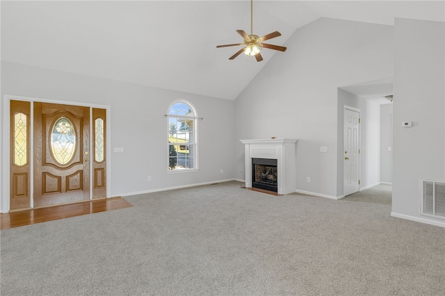 unfurnished living room featuring light carpet, high vaulted ceiling, and ceiling fan