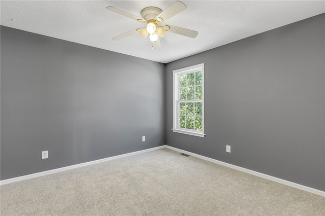 carpeted empty room with ceiling fan and a textured ceiling