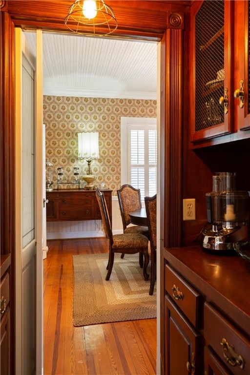 interior space featuring light wood-style flooring, baseboards, and wallpapered walls