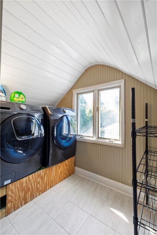 clothes washing area with washer and dryer, laundry area, baseboards, and tile patterned floors