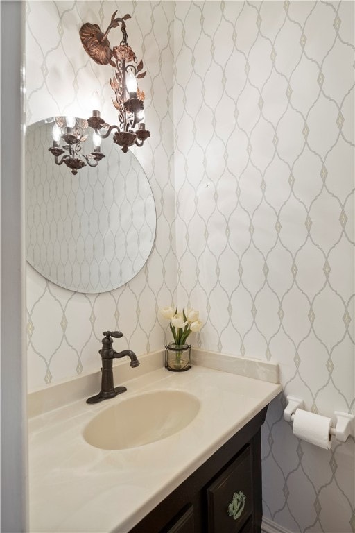 bathroom featuring vanity and wallpapered walls