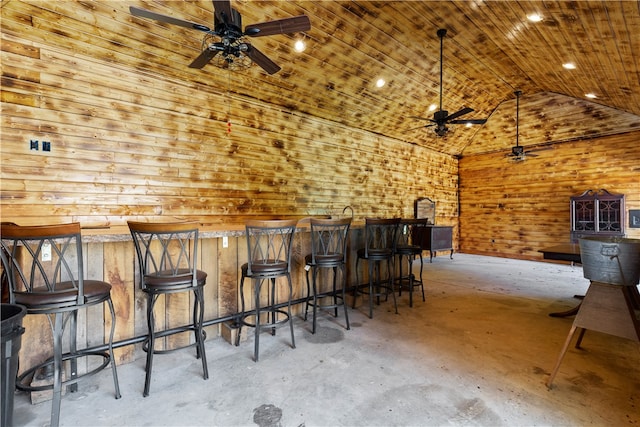 bar with lofted ceiling, ceiling fan, concrete flooring, wooden ceiling, and bar