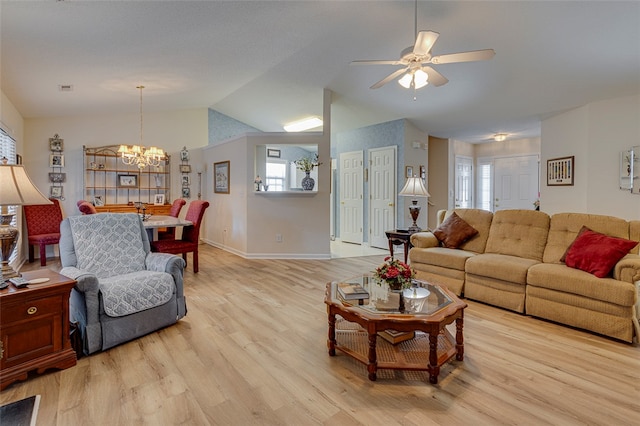 living room with lofted ceiling, ceiling fan with notable chandelier, and light hardwood / wood-style floors