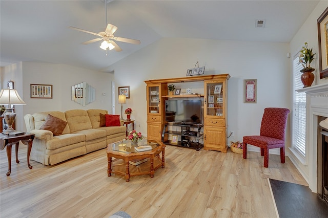 living room with ceiling fan, light wood-type flooring, and lofted ceiling