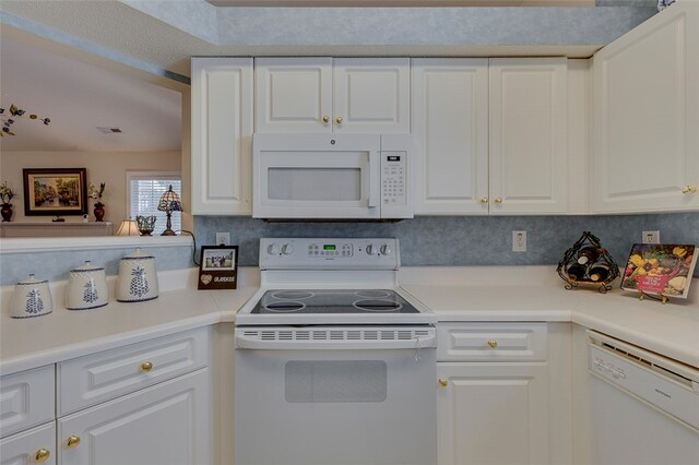 kitchen with tasteful backsplash, white appliances, and white cabinetry