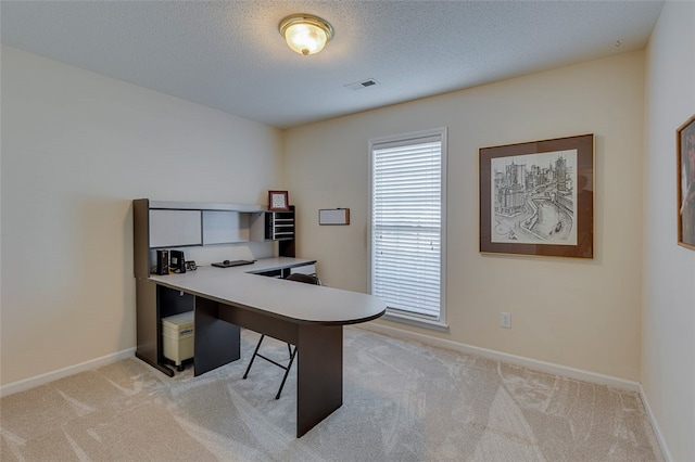 home office featuring light colored carpet and a textured ceiling