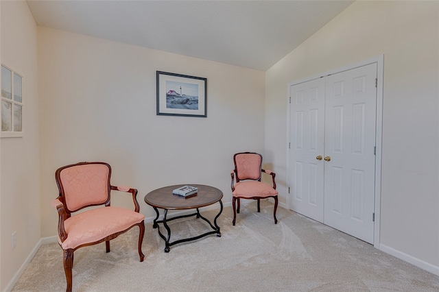 living area with lofted ceiling and light colored carpet