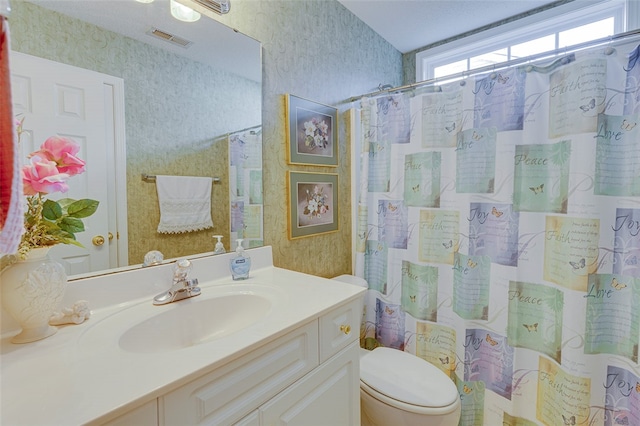 bathroom featuring vanity, toilet, and curtained shower