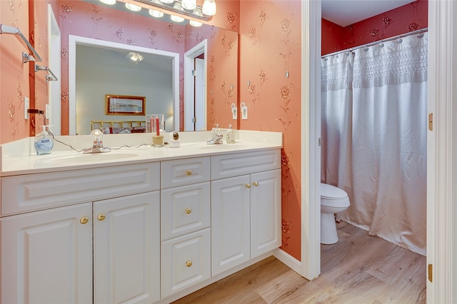 bathroom with walk in shower, vanity, hardwood / wood-style floors, and toilet