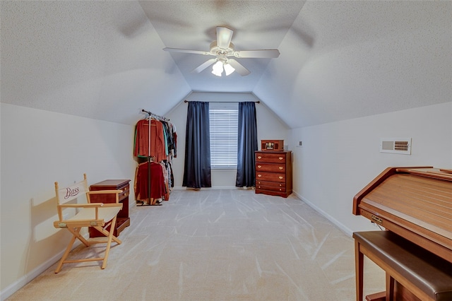 interior space featuring lofted ceiling, light carpet, a textured ceiling, and ceiling fan