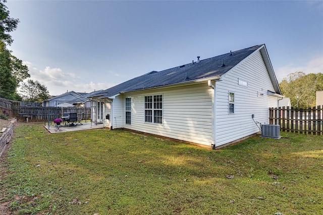 rear view of house featuring a lawn, a patio, and central air condition unit