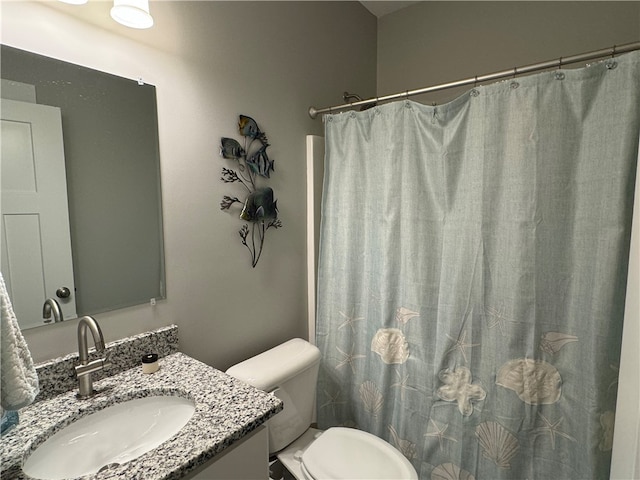 bathroom featuring vanity, toilet, and curtained shower