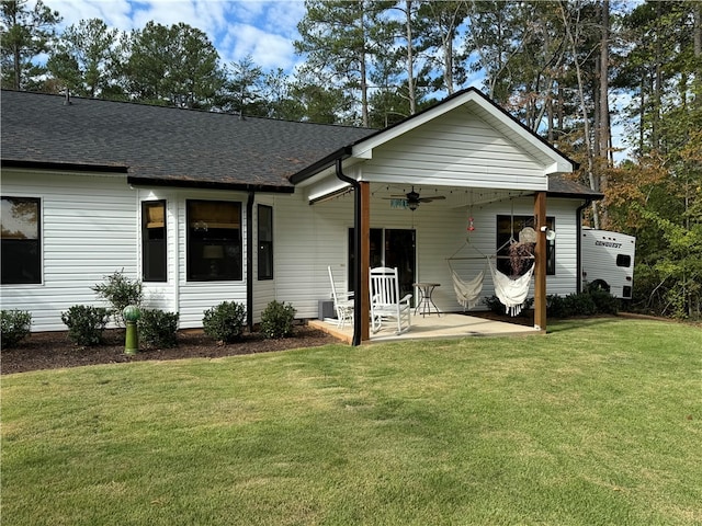 ranch-style home featuring a front lawn, ceiling fan, and a patio area