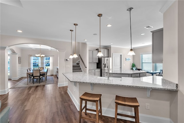 kitchen with plenty of natural light, kitchen peninsula, and stainless steel fridge with ice dispenser