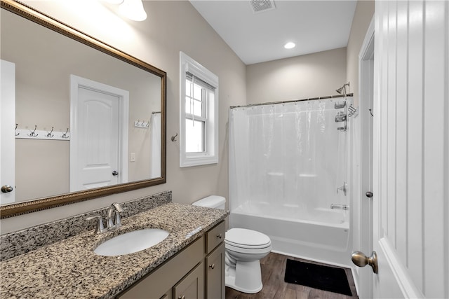 full bathroom with hardwood / wood-style floors, shower / bath combo, vanity, and toilet