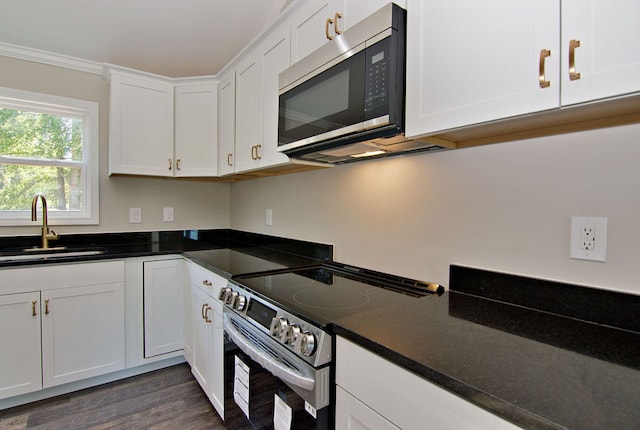 kitchen featuring sink, white cabinetry, stainless steel appliances, dark wood-type flooring, and ornamental molding