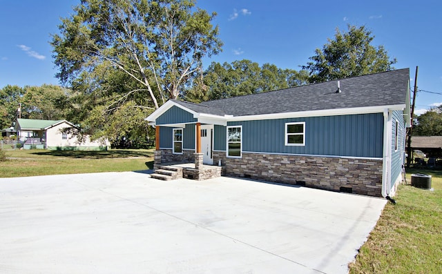 view of front of home with a front yard and central AC