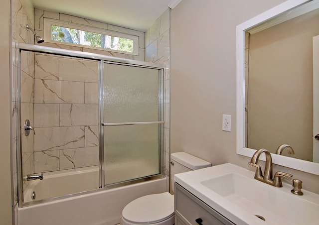 full bathroom with vanity, toilet, and bath / shower combo with glass door