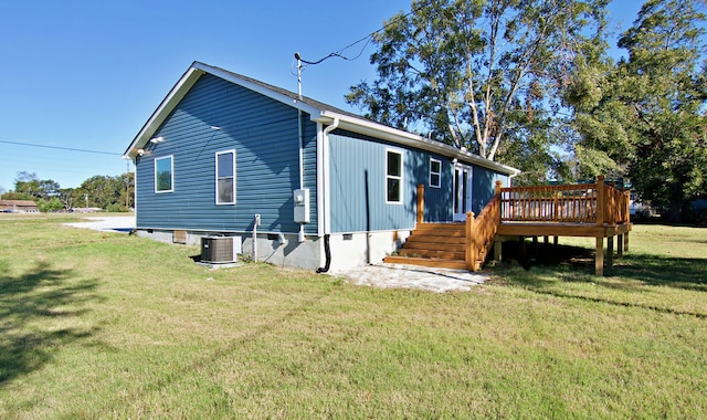 view of home's exterior featuring cooling unit, a wooden deck, and a lawn