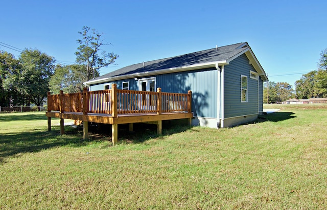 rear view of house with a deck and a lawn