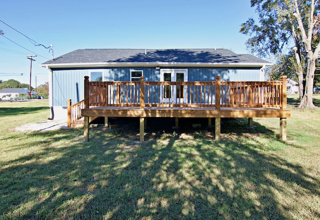 rear view of property featuring a yard and a wooden deck