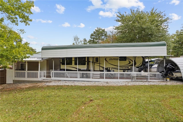 rear view of house featuring a lawn, covered porch, and a carport