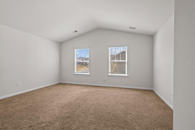 unfurnished room featuring lofted ceiling and carpet flooring