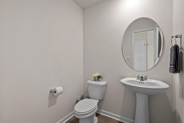 bathroom featuring toilet and wood-type flooring