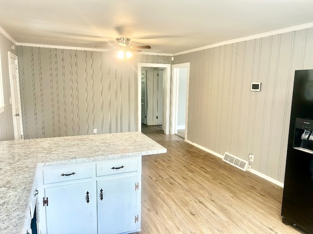 kitchen with crown molding, white cabinetry, light wood-type flooring, and ceiling fan